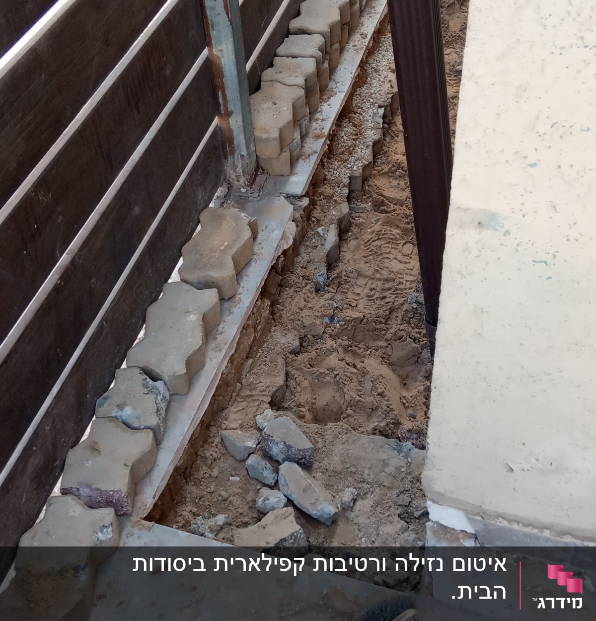 כלי עבודה וחול ליד גדר עץ